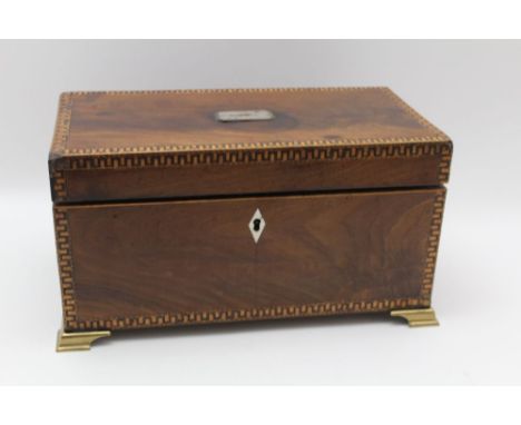A GEORGE III MAHOGANY TEA CADDY, hinged lid reveals two inner caddies flanking a glass, raised on brass ogee bracket feet, 30