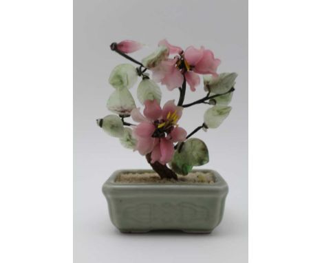 A MINIATURE CHINESE BONSAI TREE, with celadon ceramic base, carved hardstone flowers, and possibly jade leaves, 15cm high 