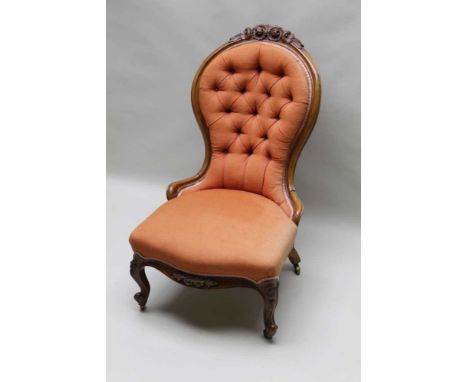 A 19TH CENTURY SHOW WOOD FRAMED BUTTON BACKED NURSING STYLE CHAIR with floral carved crest rail &amp; front rail over scrolli