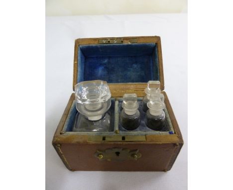 A Victorian rectangular leather casket, the hinged cover revealing a decanter and three other bottles with glass stoppers, A/