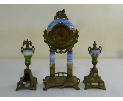 An early 20th century French mantle clock set, the spherical clock with brass dial and metal mounts, flanked by two vase form