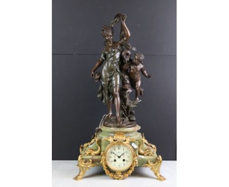 Early 20th Century French onyx clock with applied gilt metal dolphins, the ivorine dial with black Arabic numerals and floral
