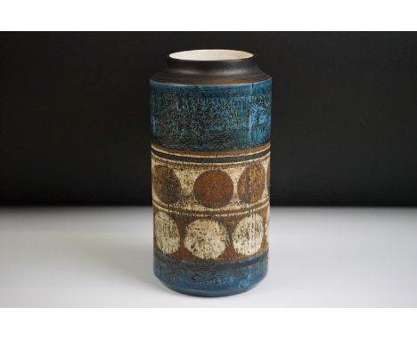 Troika pottery cylindrical lamp base decorated with a double band of circles in cream &amp; brown, on a textured blue ground,