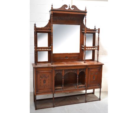 An Edwardian walnut mirror back sideboard with broken swan neck pediment above five bevelled edge plates with ring turned sup