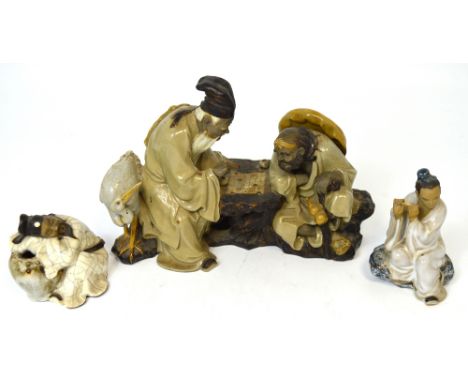 A Chinese pottery figure group of two gentlemen playing a board game, one with a crane by his side, the second leaning on a s