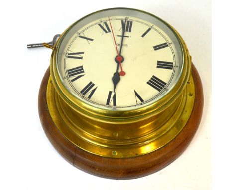 A large brass ship's clock with circular dial inscribed 'Smiths' and with Roman numerals and slow/fast indicator, now mounted