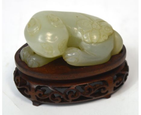 A Chinese carved mutton fat jade figure of a cat with butterfly upon its back on shaped rosewood stand, length 6cm. *Provenan