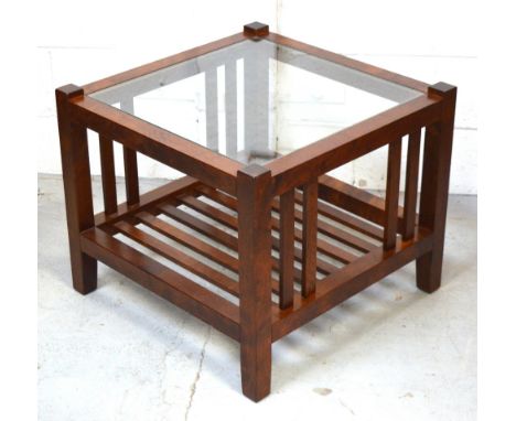 A modern square coffee table with lower slat shelf and glass top.