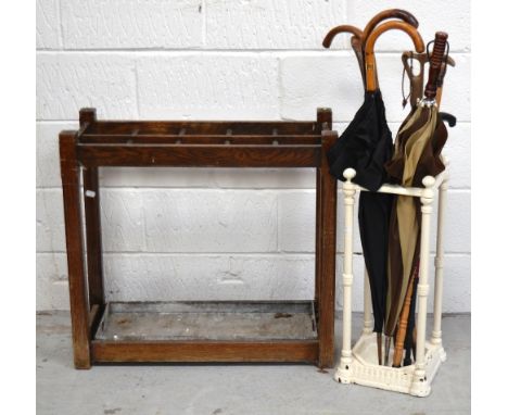 A white painted cast iron stick/umbrella stand with a quantity of sticks and umbrellas and similar rectangular wood example o