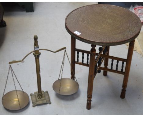 An Indian brass tabletop on a folding turned base, diameter 42cm and a vintage pair of brass scales, central column base moun