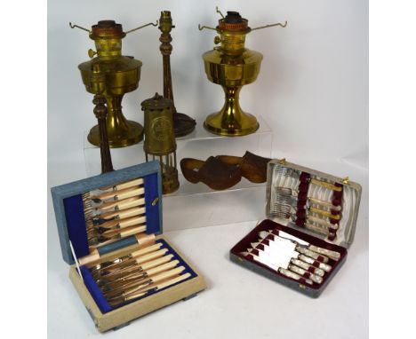Two cases of plated flatware, a miner's lamp, two brass oil lamps lacking shades and a small pair of vintage wooden clogs.