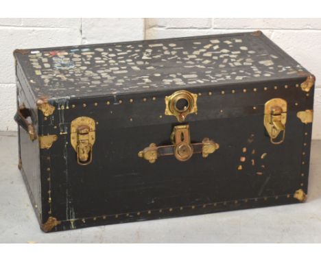 A black 20th century trunk with brass fittings and stud decoration, width 80cm.