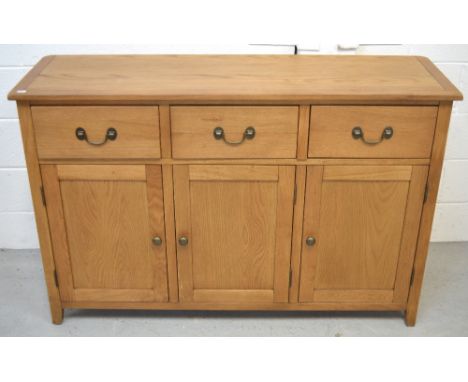 A modern oak sideboard, three drawers over three lower cupboard doors on bracket feet, length 130cm.