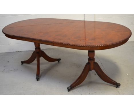 A reproduction dining table on twin pedestal supports and a matching yew wood display cabinet, Greek key frieze to the top ov