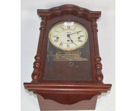 A reproduction wooden cased 30 hour German wall clock, the dial inscribed 'Hermle' and set with Roman Numerals, height 45cm.
