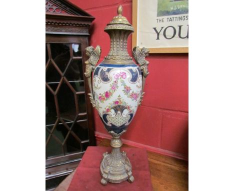 A late 20th Century cast brass mounted ceramic urn, printed and painted with swags of flowers within a blue boarder