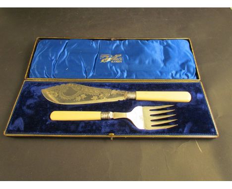 A white metal fish knife and fork set with silver cuffs in original case