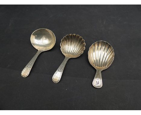 Three Georgian silver caddy spoons all with bright cut decoration, two with shell form bowls, 26g