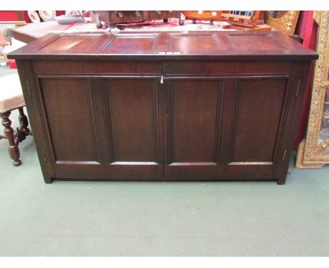 An 18th Century panelled oak coffer the hinged lid over two doors on stile feet, with internal shelf, 78cm x 146cm x 58cm