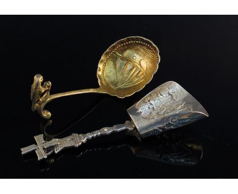A Dutch 19th Century silver gilt caddy spoon with parrot finial and embossed boat to bowl, and another of shovel form with wi