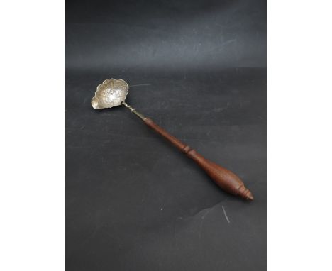 A George II silver toddy ladle embossed bowl with flower and scroll decoration, makers mark W.E?, London 1757, with turned ha