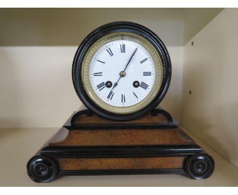A 19th century walnut and ebony French mantle clock with 8 day movement strikes on a bell, Roman numerals to white enamel dia