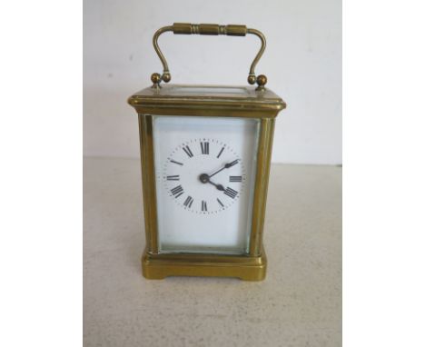 An 8 day French carriage clock with key, white enamel dial with Roman numerals