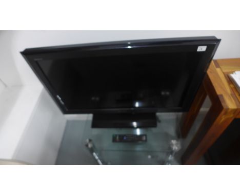 A Sony flat screen TV model KDL-3255500 on glass stand - in working order