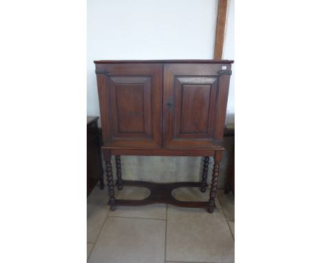 An oak two door cupboard on a sugar barley twist stand with a fitted interior of pigeon holes and five drawers - Height 152cm