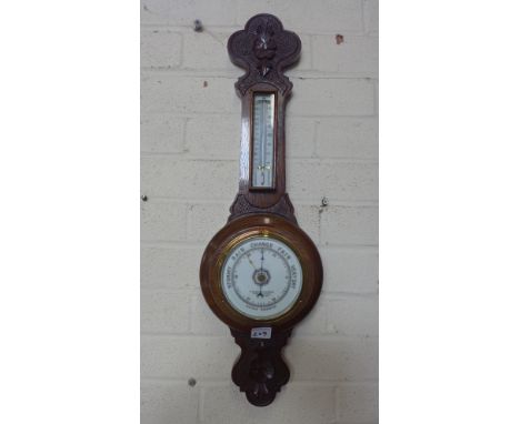 A carved oak aneroid barometer with thermometer retailed by Sidney Campkin and Sons Cambridge - Height 66cm