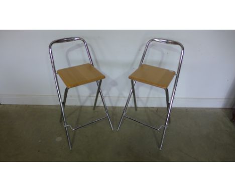 A pair of modern chrome stools with light beech seats
