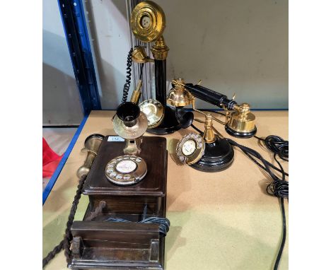 A vintage style wall mounted telephone in brass and wood, 33 cm; a similar stick telephone; another similar -&nbsp;all 3 phon