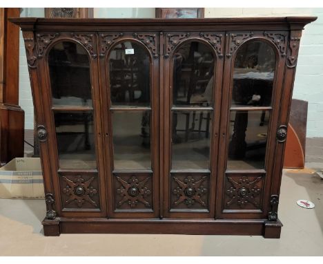 An Arts & Crafts mahogany bookcase enclosed by 4 arch panel doors, with fretted and beaded decoration, width 130 cmBookcase t