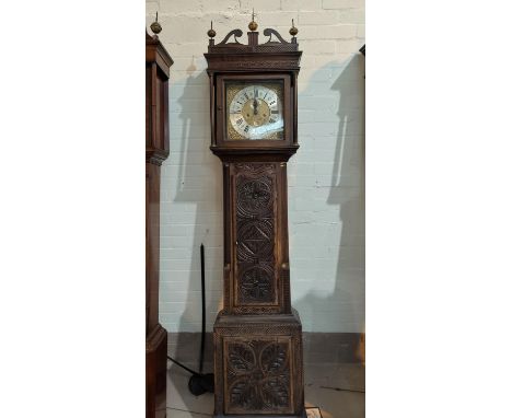 An 18th century oak longcase clock with later carved decoration, having fretted swan neck pediment, brass finials and turned 