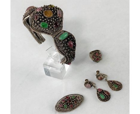 An ornate Eastern silver bracelet set with multi coloured stones with matching earrings, ring and broochCannot confirm that t