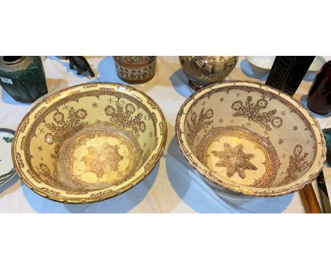 An 18th/19th century pair of large Hispano-Moresque bowls of tapering form, tin glazed with copper lustre stylized floral dec