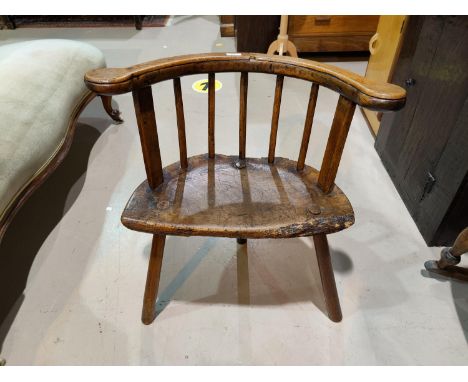 A late 17th/early 18th century rustic country made armchair, Windsor style with low stick back, solid seat and 3 peg legsBack