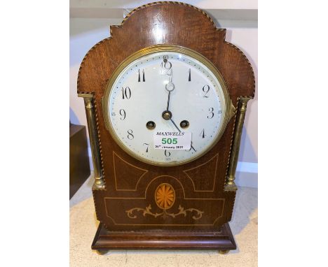 An Edwardian mantel clock in Sheraton inlaid arch top case, with white enamel dial and French drum movement striking on gong,