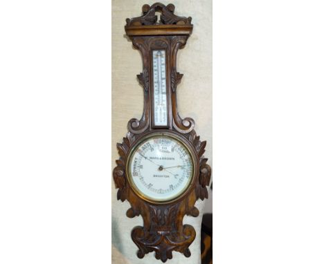 An Edwardian barometer with thermometer in floral carved banjo shaped case, by Ward & Brown, Brighton, height 88 cm -thermome