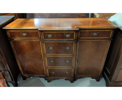 A Georgian style crossbanded mahogany breakfront side cabinet with 3 frieze and 3 central drawers and 2 side cabinets, on bra