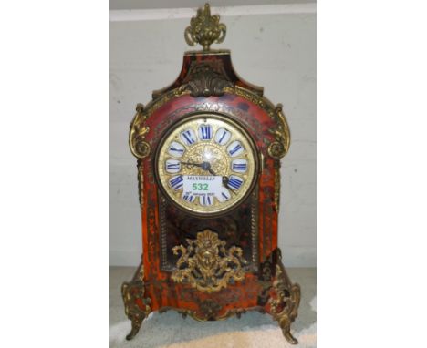 A 19th century French mantel clock in arch top boulle case with ornate ormolu finial, feet and mounts, gilt dial with raised 