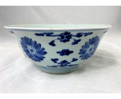 A Chinese blue and white bowl with flared rim bearing seal mark to base, decorated with flowers etc (some chipping and restor