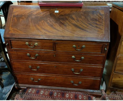 A Georgian figured mahogany fall front bureau with boxwood and ebony stringing, 3 long and 2 short drawers, on ogee bracket f
