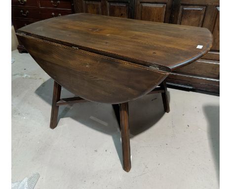 An Ercol dark elm drop leaf dining table 