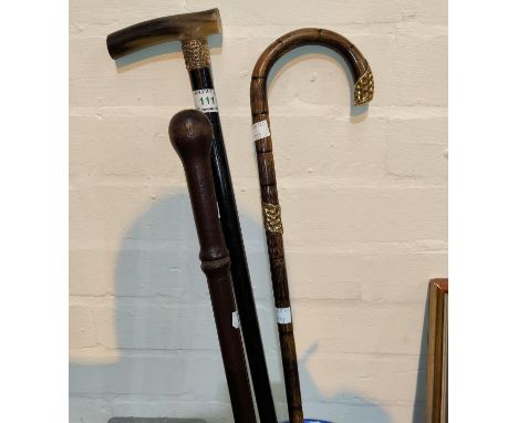 A 19th century ebony walking stick; a similar bamboo cane; a constabulary nightstick 