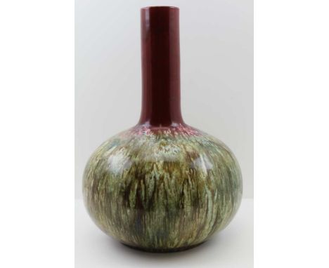 A 20TH CENTURY ART POTTERY VASE of globe and shaft form, deep red glazed neck on a green / brown drip glazed body, in the man