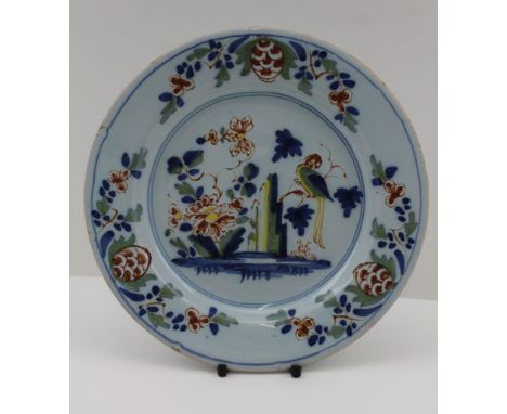AN EARLY 18TH CENTURY LAMBETH LONDON DELFTWARE PLATE, polychrome painted decoration with parrot and a floral border, 19cm dia