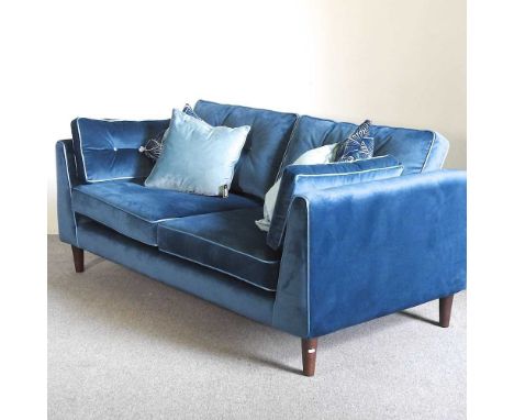 A Sofology blue velvet upholstered sofa, with a button back, on turned legs, with loose cushions189w x 97d x 70h cm