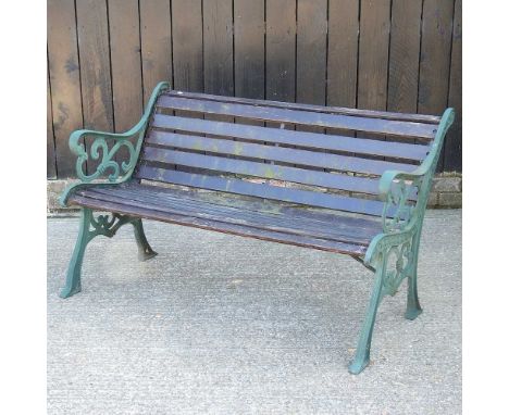 A slatted wooden garden bench, with green painted metal ends130w x 62d x 73h cm