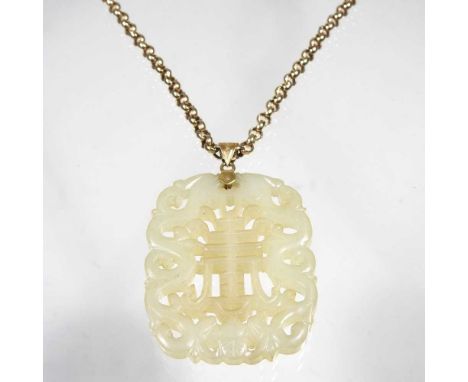 A Chinese jade pendant, fret carved with two dragons amongst scrolls, with a gilt mount, suspended on an antique 9 carat gold